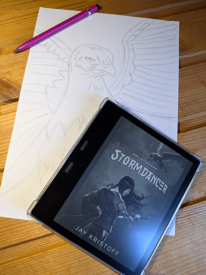 Jay Kristoff: Der Lotuskrieg - Stormdancer. Eine Zeichnung eines Greifen, im Vordergrund ein Kindle mit dem Cover vom Buch, einer weiblichen Samurai.